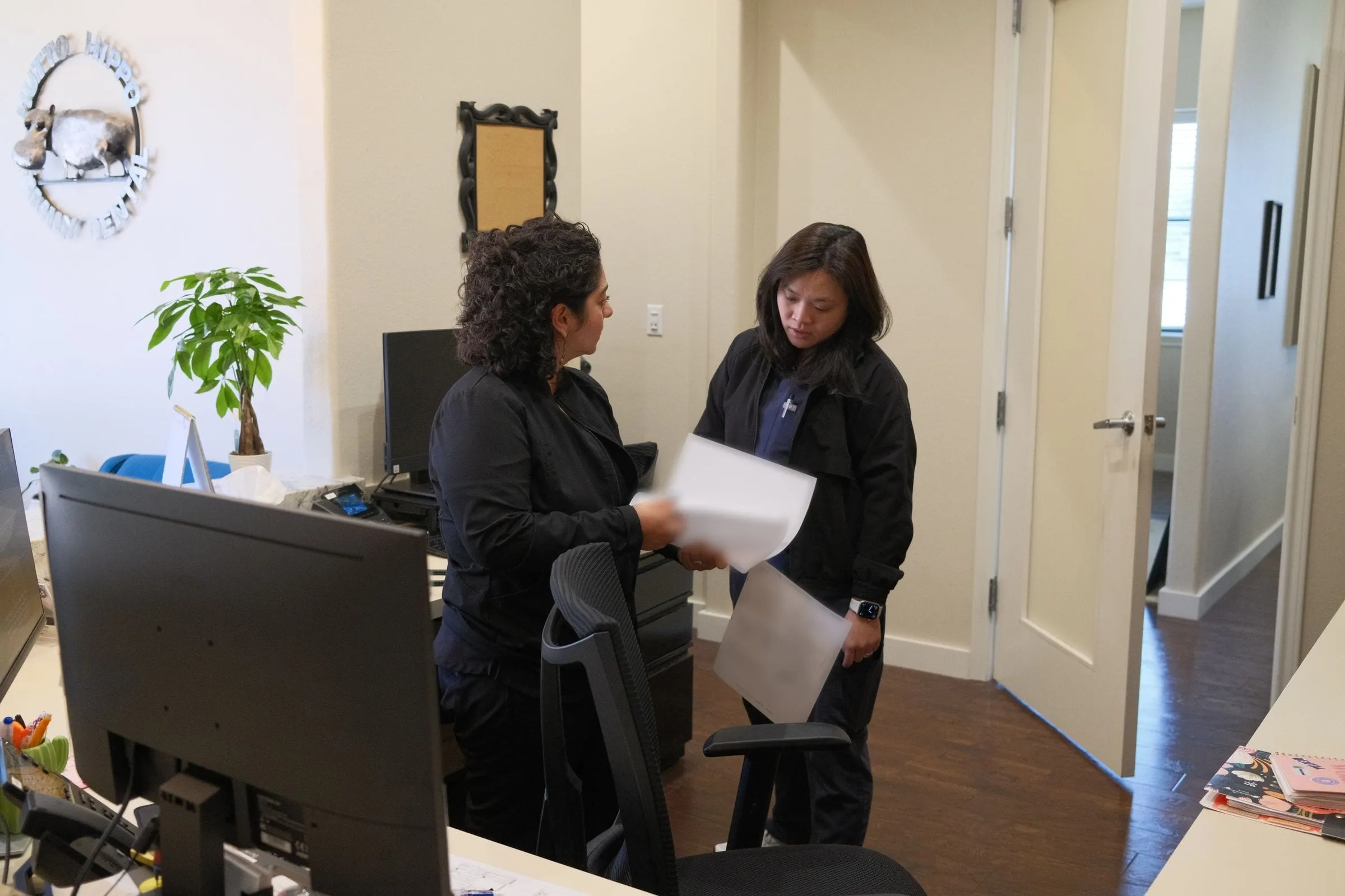 Dr. Han Nguyen and Jennifer talking at the front desk of Hutto Hippo Family Dental