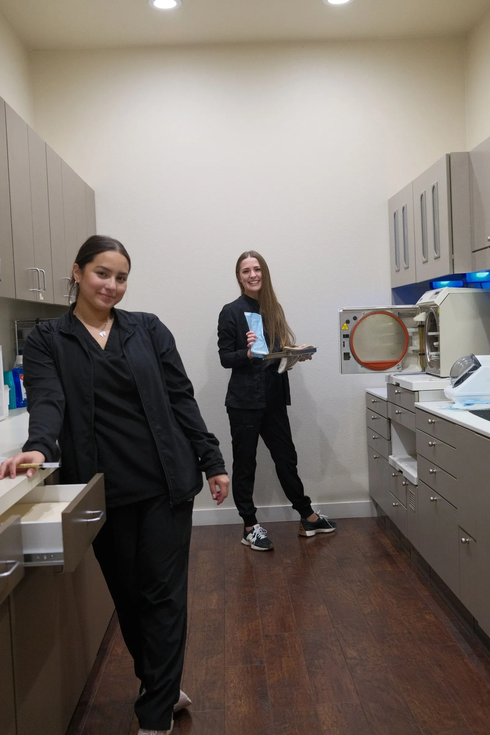 Lucia and Kelly smiling in the back office at Hutto Hippo Family Dental in Hutto, TX